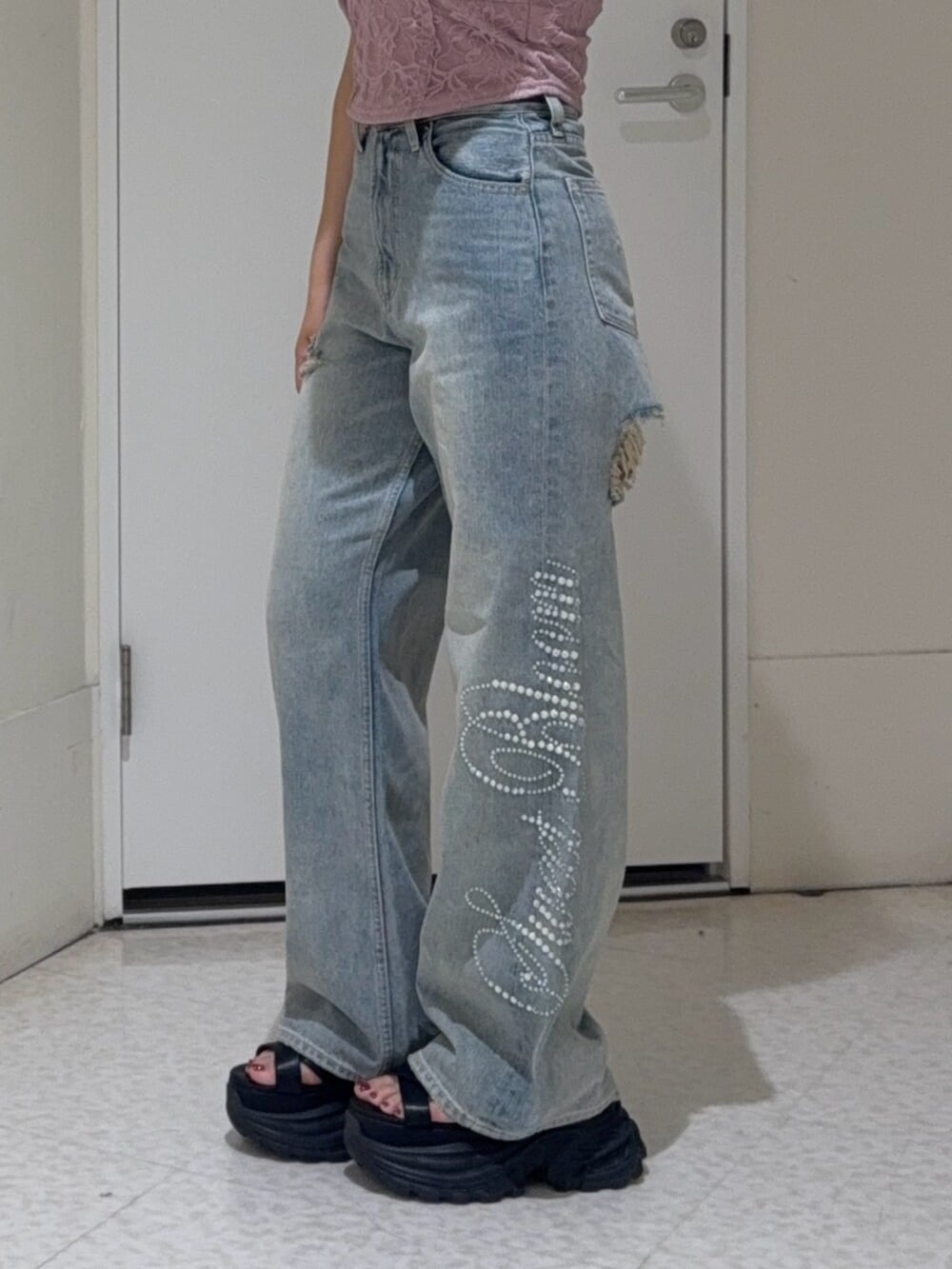 ブラック系のサンダル、ブルー系のデニムパンツ、ブラック系のTシャツ/カットソーを着用したレディースの夏コーディネートの4枚目の写真