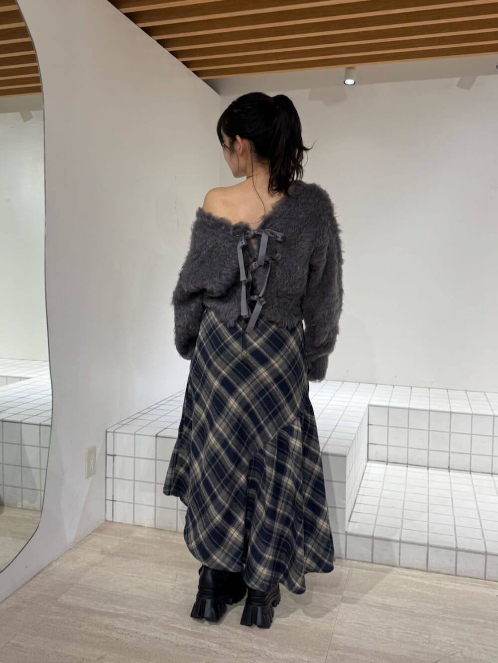 ブルー系のスカート、ブラック系のブーツ、グレー系のニット/セーターを着用したレディースの秋コーディネートの3枚目の写真