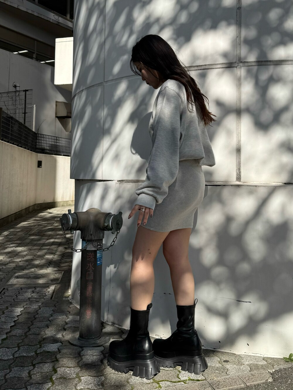 グレー系のワンピース、ブラック系のブーツを着用したレディースの秋コーディネートの3枚目の写真