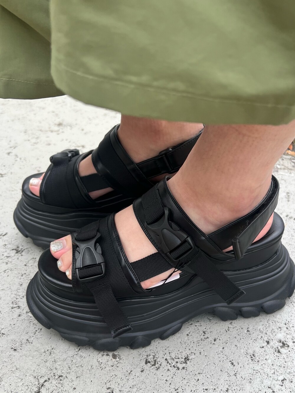 ブルー系のデニムパンツ、ブラック系のハンドバッグ、グレー系のタンクトップを着用したレディースの夏コーディネートの8枚目の写真