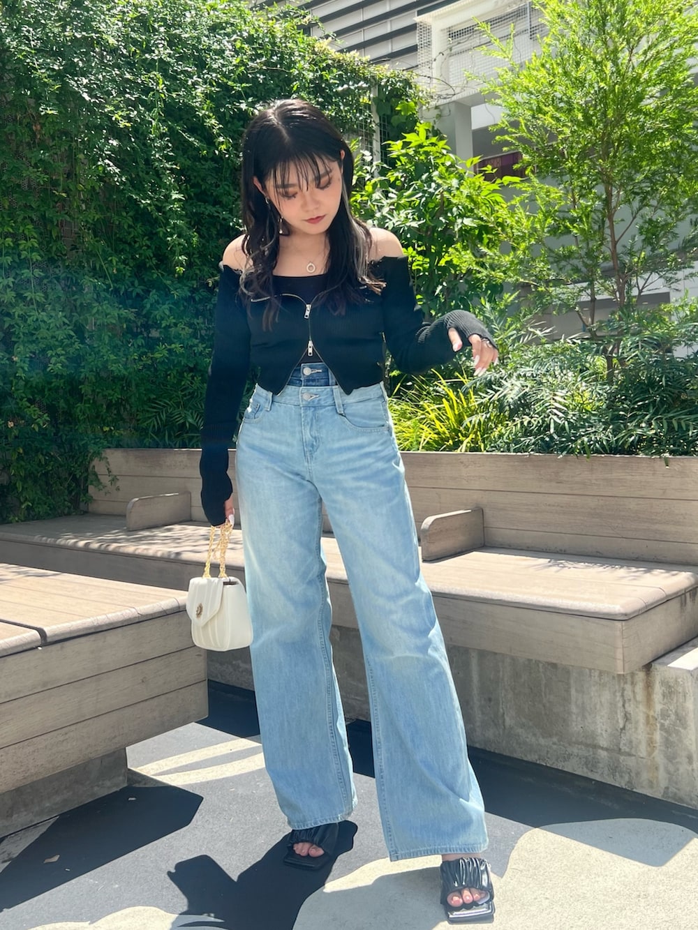 ブルー系のデニムパンツ、ブラック系のニット/セーター、ブラック系のサンダルを着用したレディースの夏コーディネートの2枚目の写真