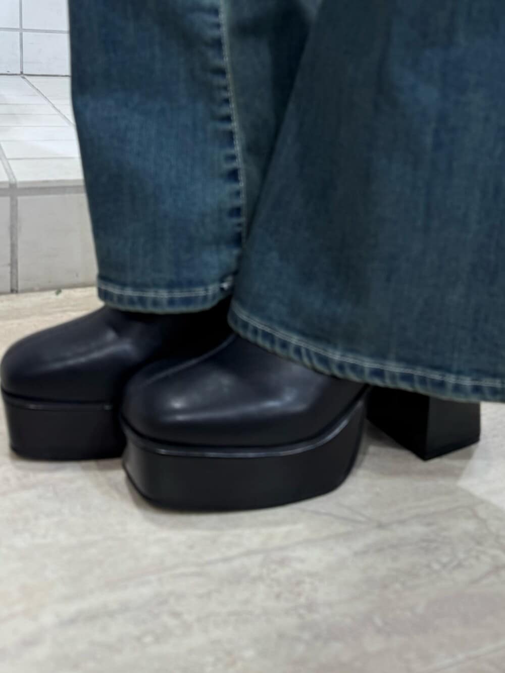 ブラック系のブルゾン、ブラック系のブーツ、ブラック系のワンピースを着用したレディースの冬コーディネートの5枚目の写真