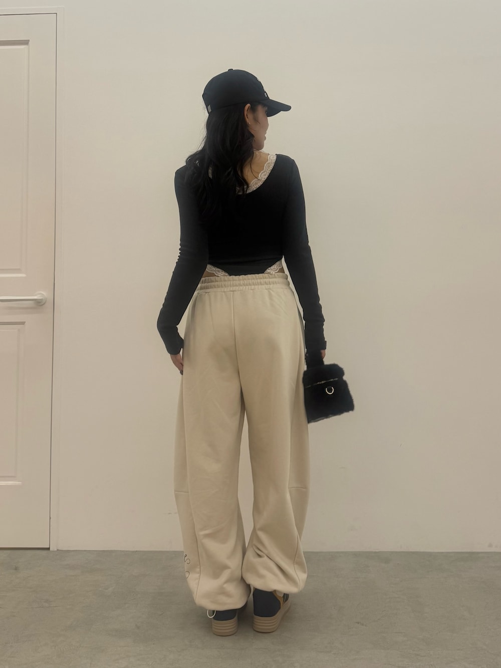 グレー系のTシャツ/カットソー、ホワイト系のスウェットパンツ、ブラック系のショルダーバッグを着用したレディースの秋コーディネートの3枚目の写真