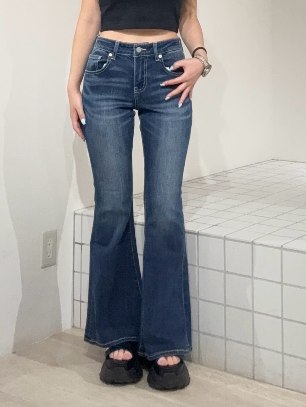 ブラック系のサンダル、ブルー系のデニムパンツ、ブラック系のタンクトップを着用したレディースの夏コーディネートの5枚目の写真
