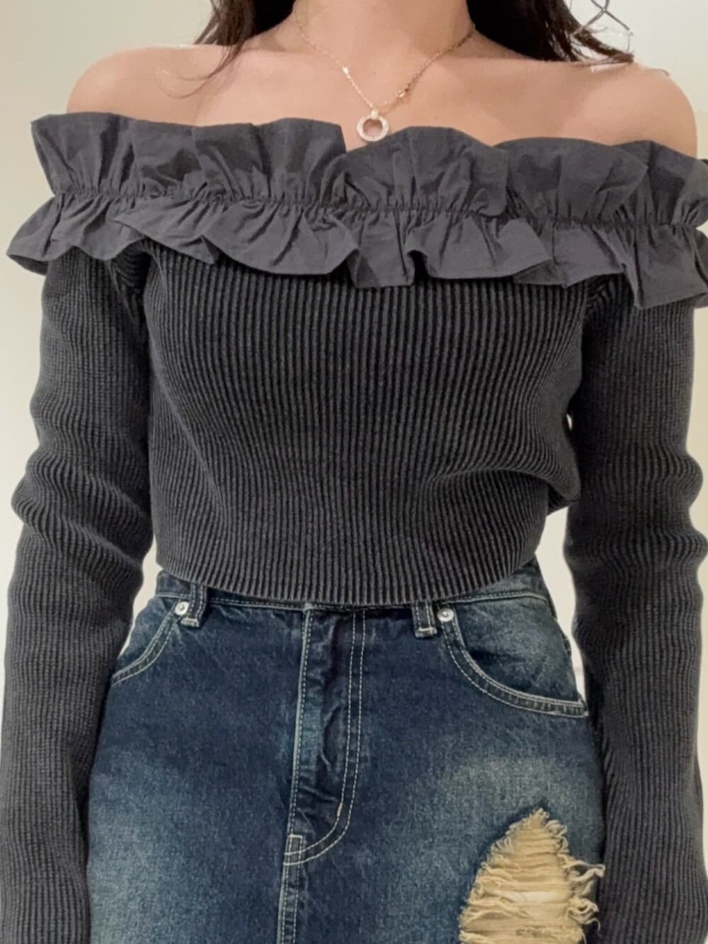 ブラック系のブーツ、ブルー系のデニムスカート、ブラック系のニット/セーターを着用したレディースの冬コーディネートの4枚目の写真