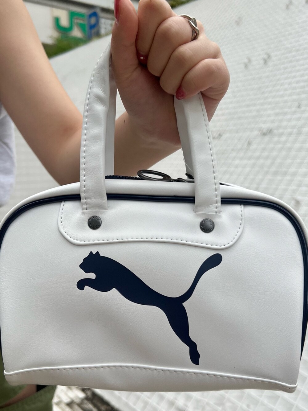 ホワイト系のハンドバッグ、グリーン系のカーゴパンツ、ブラック系のサンダルを着用したレディースの春コーディネートの8枚目の写真