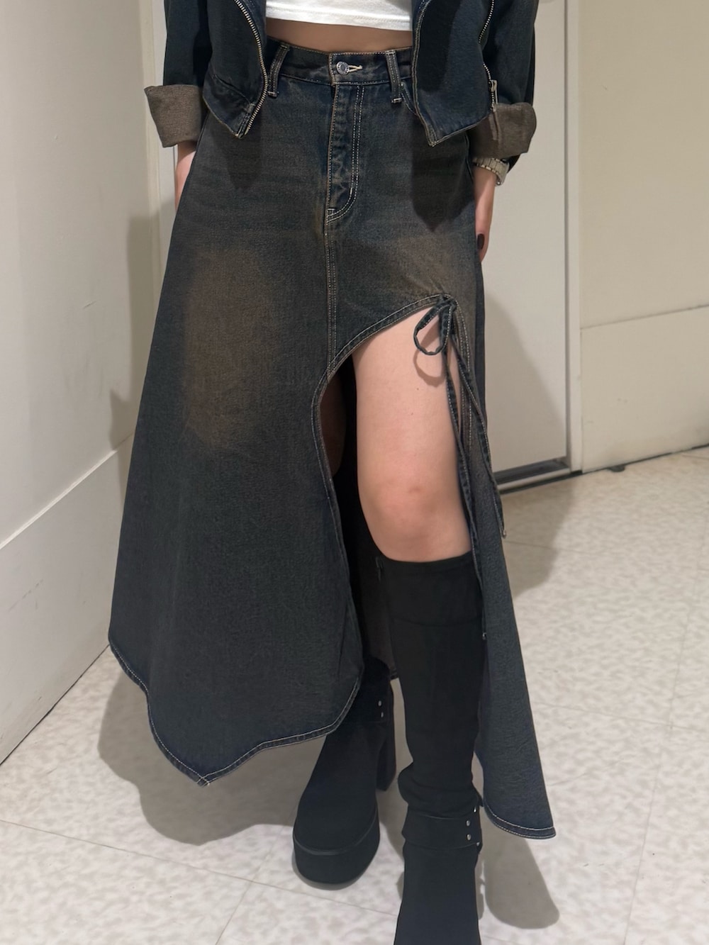 ブラック系のブーツ、ブルー系のデニムスカート、レッド系のカーディガン/ボレロを着用したレディースの秋コーディネートの5枚目の写真