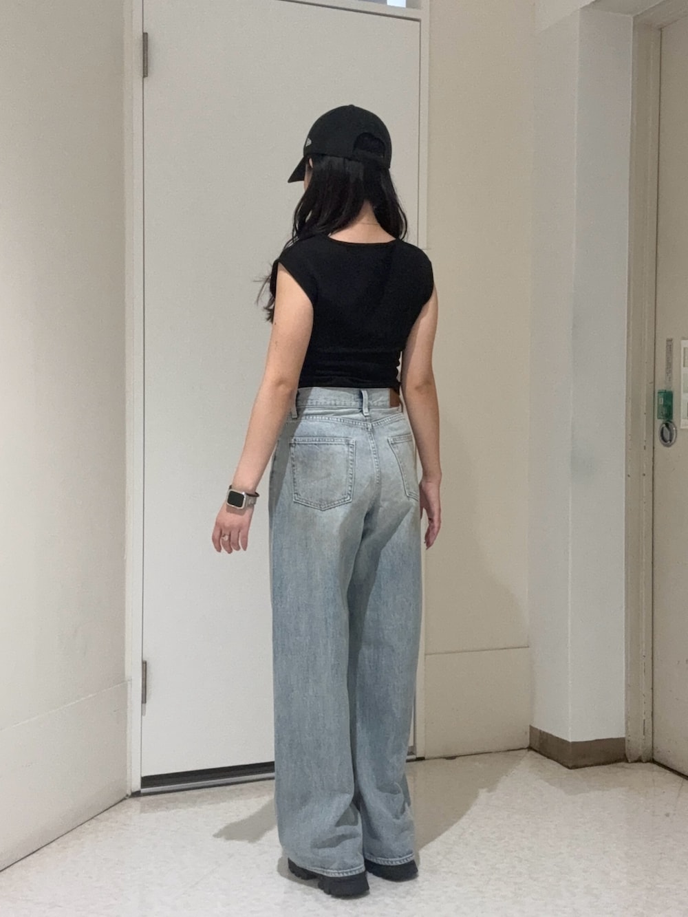 ブラック系のタンクトップ、ブラウン系のサンダル、ブルー系のデニムパンツを着用したレディースの夏コーディネートの3枚目の写真