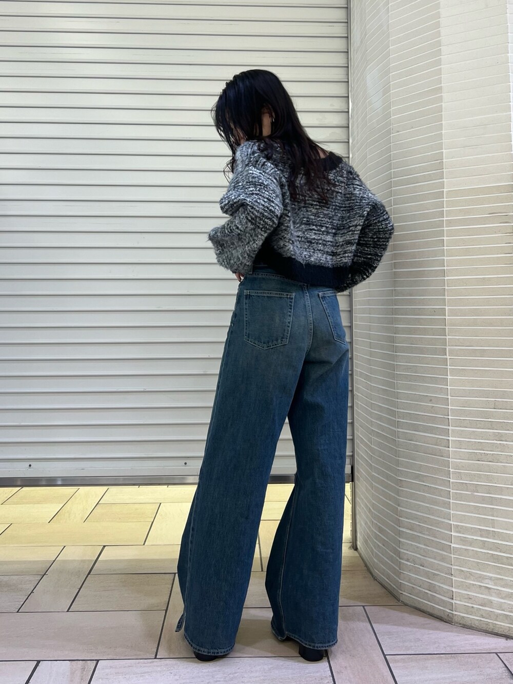 ブルー系のデニムパンツ、ブラック系のカーディガン/ボレロ、ブラック系のブーツを着用したレディースの冬コーディネートの5枚目の写真