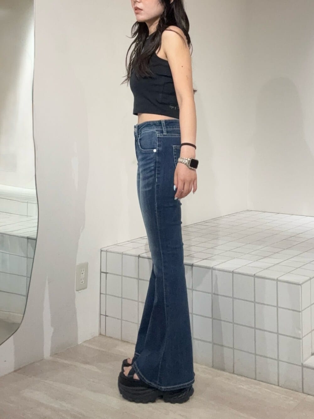 ブラック系のサンダル、ブルー系のデニムパンツ、ブラック系のタンクトップを着用したレディースの夏コーディネートの2枚目の写真