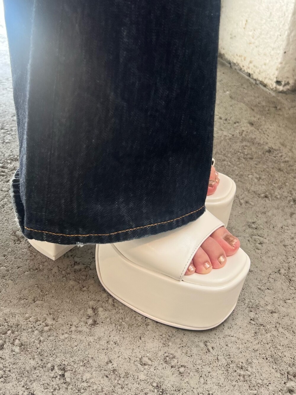 ブルー系のデニムパンツ、ホワイト系のTシャツ/カットソー、ブラック系のハンドバッグを着用したレディースの夏コーディネートの7枚目の写真