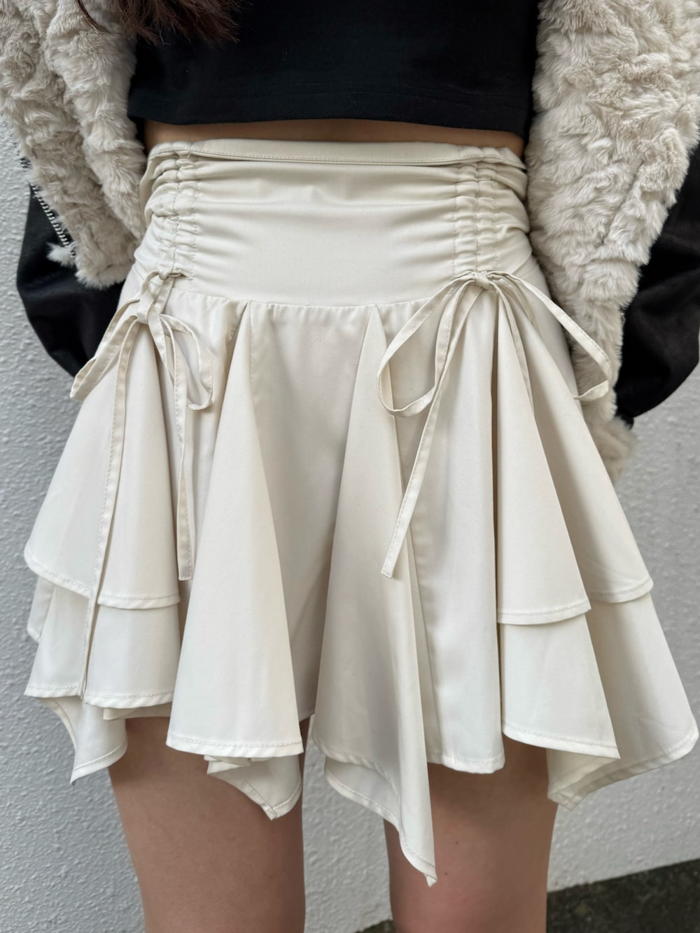 ブラック系のブーツ、ブラック系のブルゾン、ホワイト系のスカートを着用したレディースの秋コーディネートの5枚目の写真