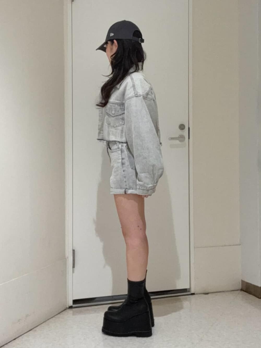 ブラック系のブーツ、グレー系のデニムパンツ、グレー系のデニムジャケットを着用したレディースの冬コーディネートの2枚目の写真