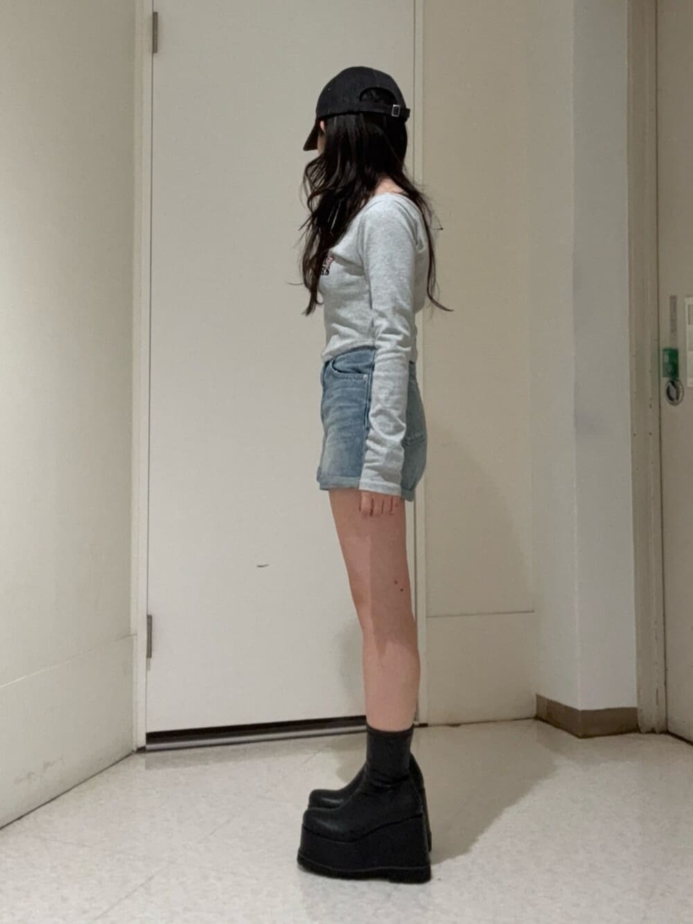 ブラック系のブーツ、ブルー系のデニムパンツ、グレー系のTシャツ/カットソーを着用したレディースの冬コーディネートの2枚目の写真