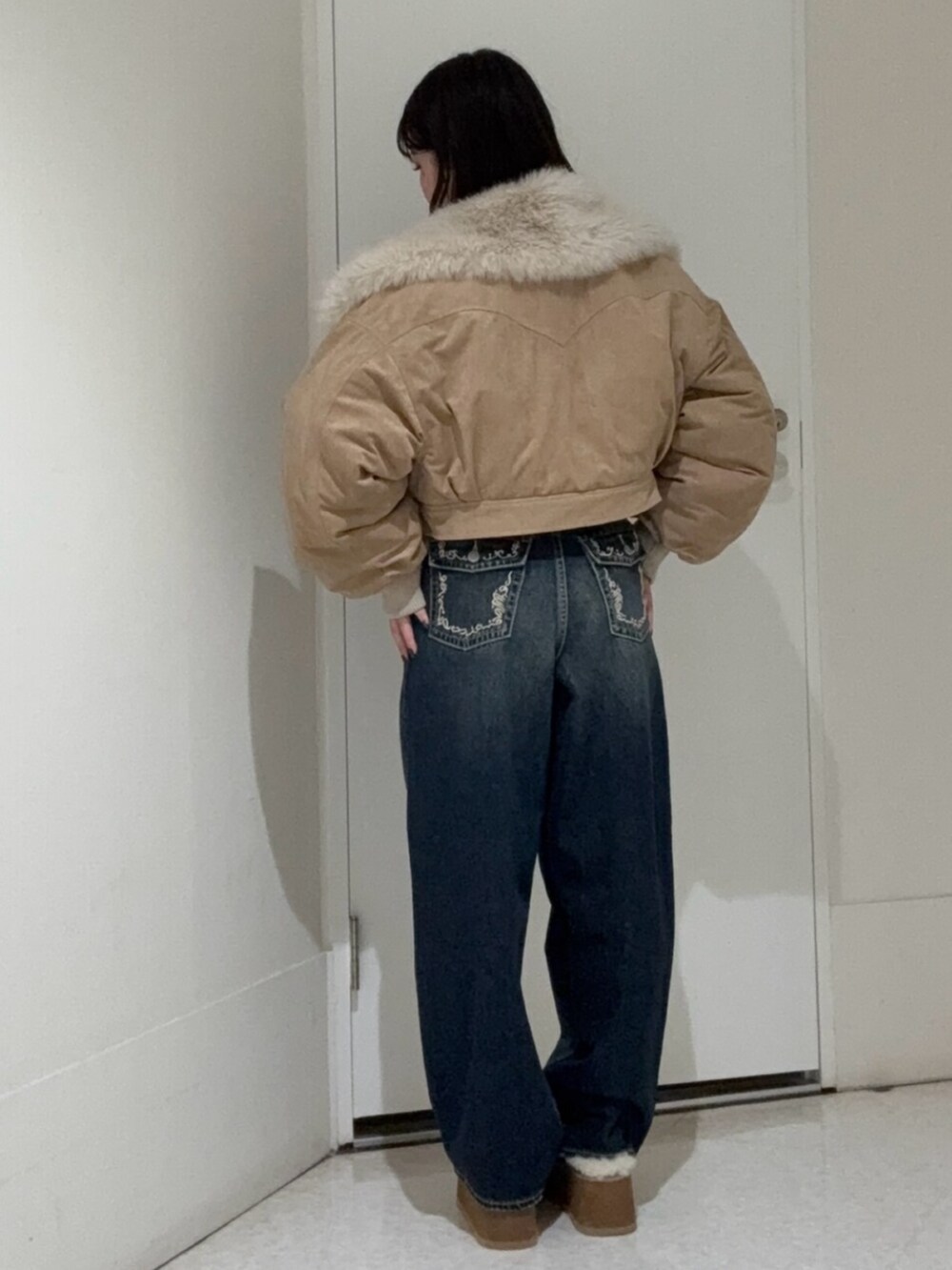 ブルー系のデニムパンツ、ベージュ系のスリッポン、ベージュ系のブルゾンを着用したレディースの秋コーディネートの3枚目の写真