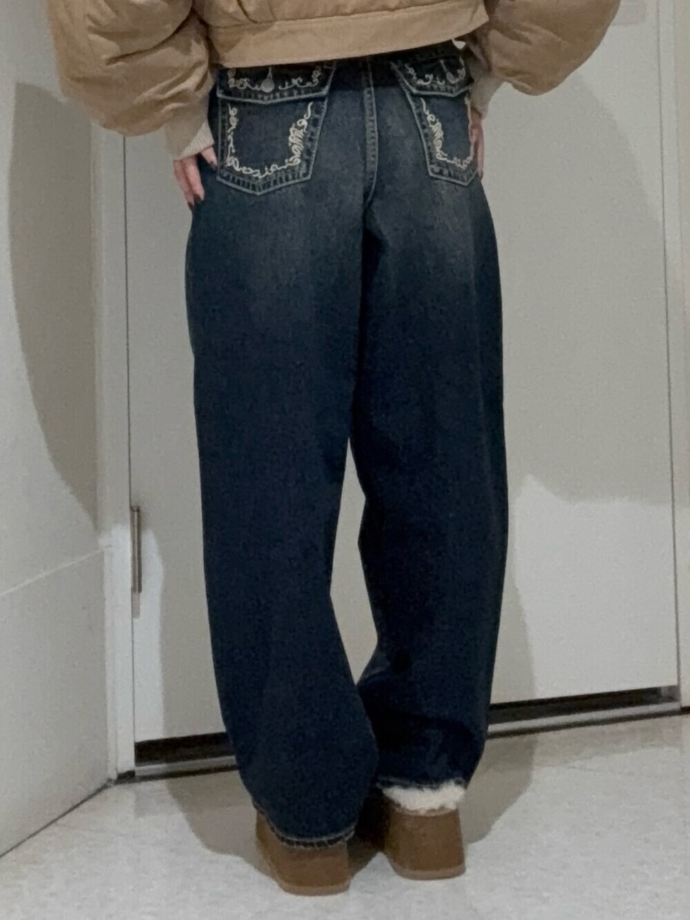 ブルー系のデニムパンツ、ベージュ系のスリッポン、ベージュ系のブルゾンを着用したレディースの秋コーディネートの5枚目の写真