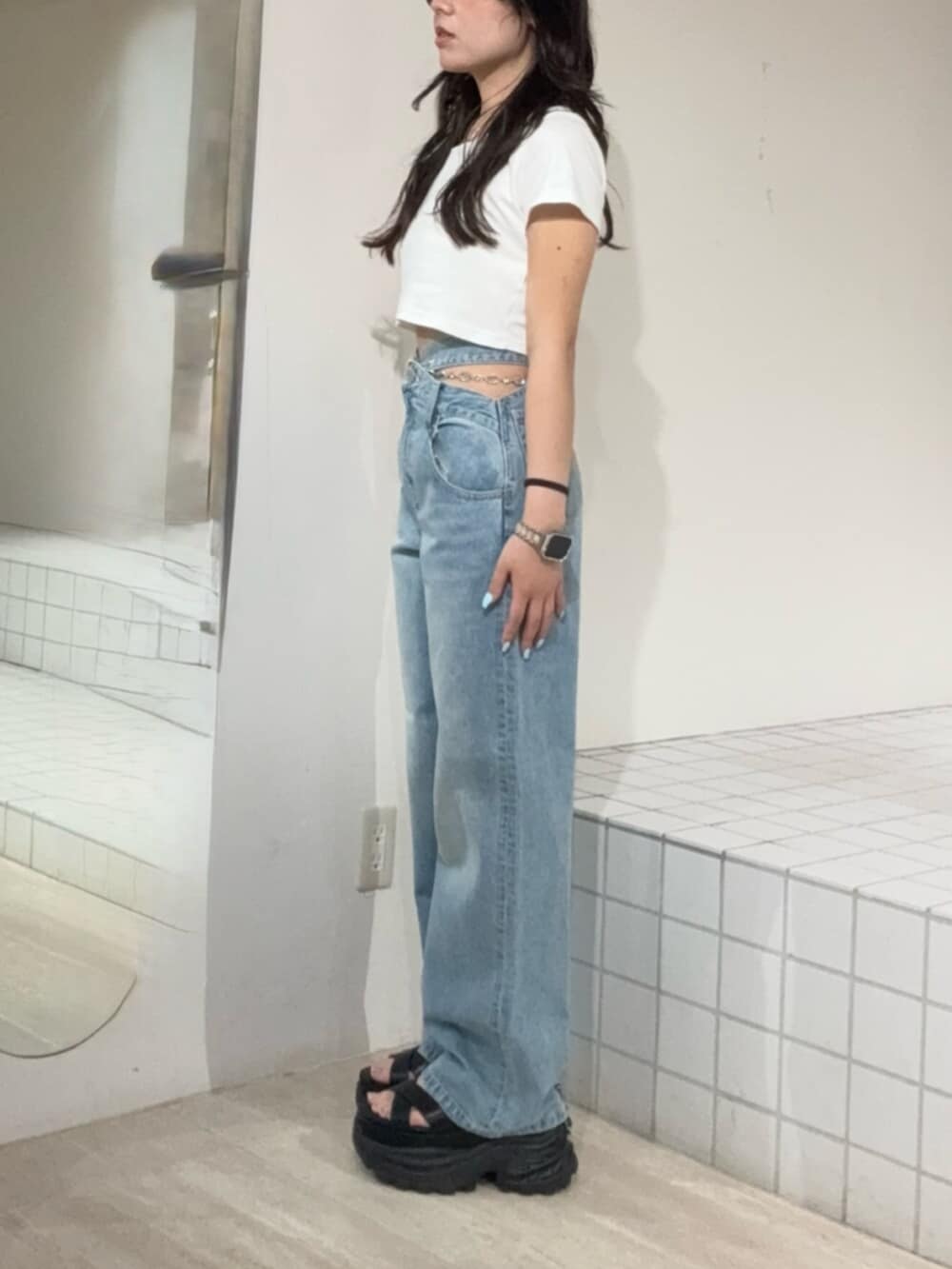 ブラック系のサンダル、ブルー系のデニムパンツ、ホワイト系のTシャツ/カットソーを着用したレディースの夏コーディネートの2枚目の写真