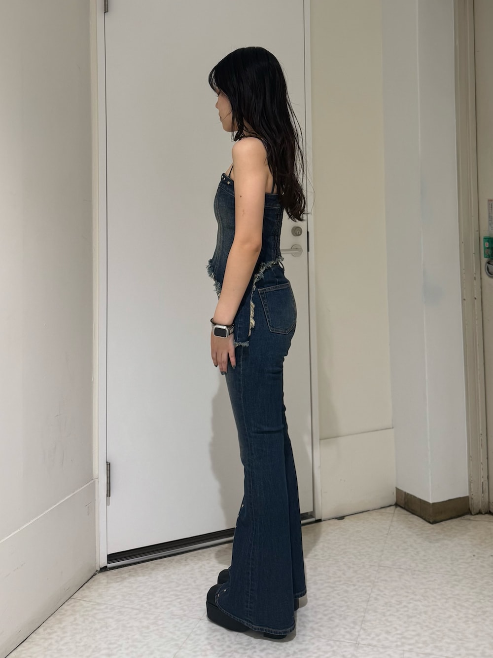 ブルー系のデニムパンツ、ブラック系のブーツ、ブルー系のキャミソールを着用したレディースの夏コーディネートの2枚目の写真