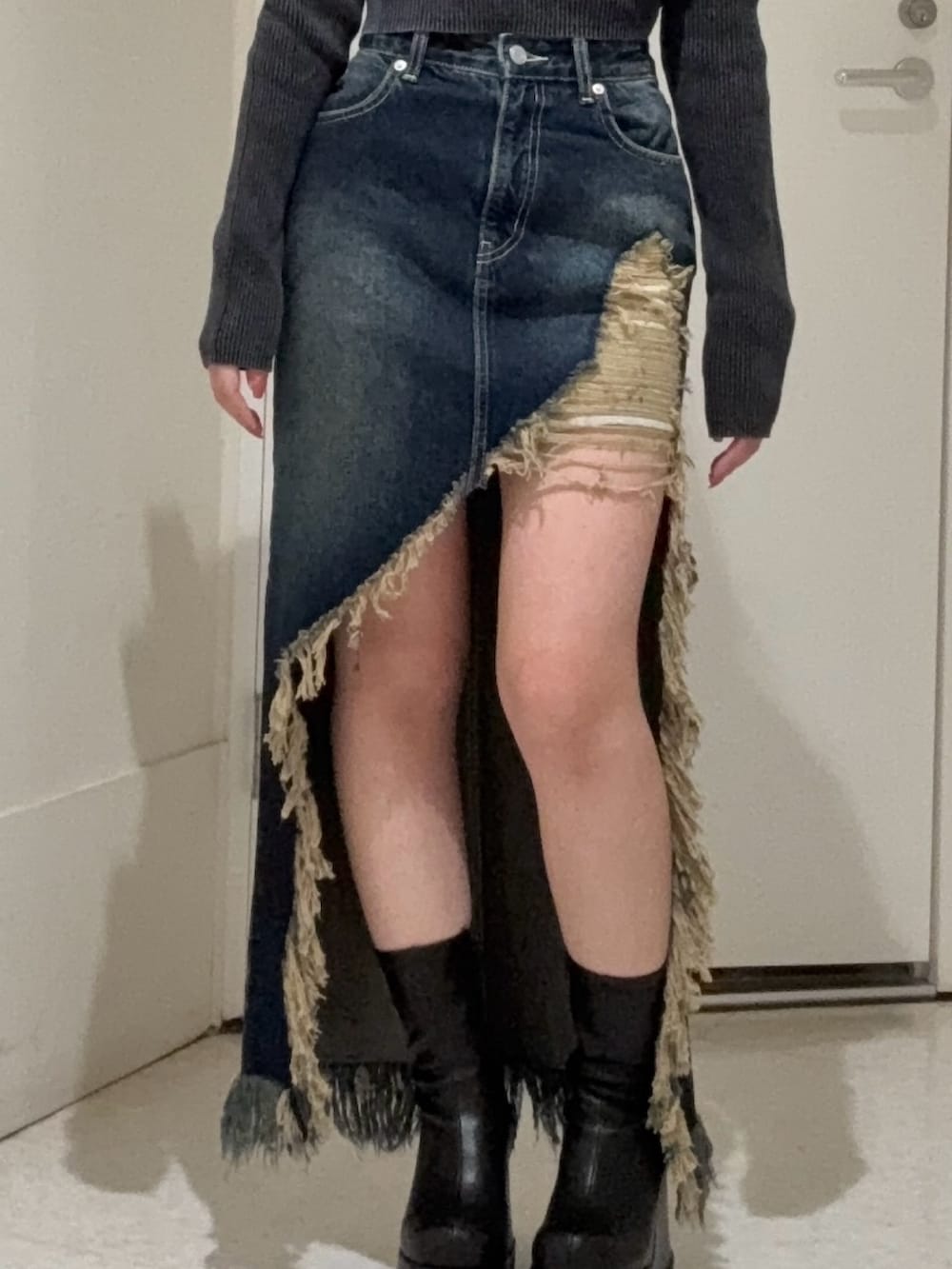 ブルー系のデニムジャケット、ブラック系のブーツ、ブルー系のデニムスカートを着用したレディースの冬コーディネートの6枚目の写真