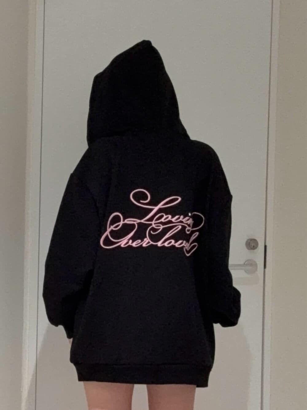 ブラック系のブーツ、ブラック系のパーカー、ブラック系のキャップを着用したレディースの春コーディネートの4枚目の写真