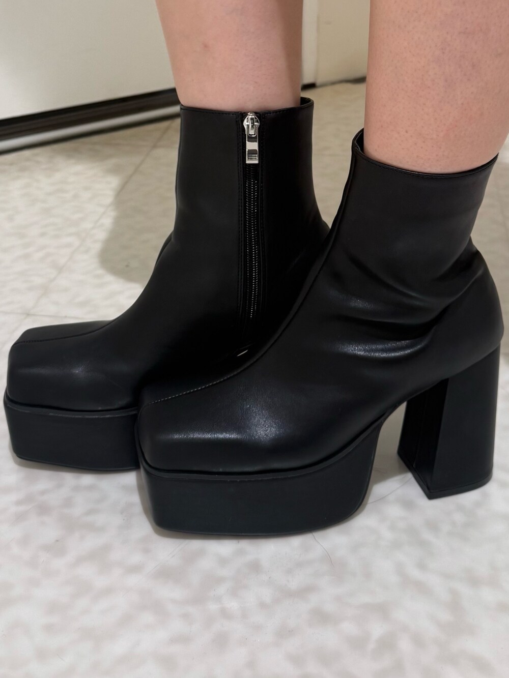 ブラック系のブーツ、ブラック系のデニムパンツ、ホワイト系のカーディガン/ボレロを着用したレディースの秋コーディネートの6枚目の写真