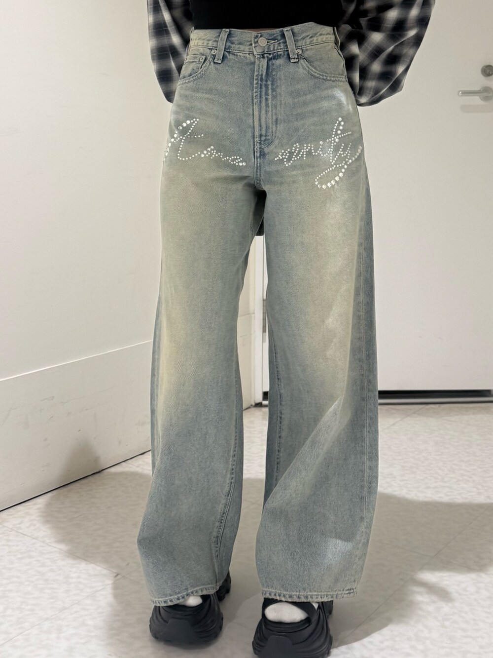 ブラック系のカーディガン/ボレロ、ブルー系のデニムパンツ、ブラック系のサンダルを着用したレディースの春コーディネートの5枚目の写真
