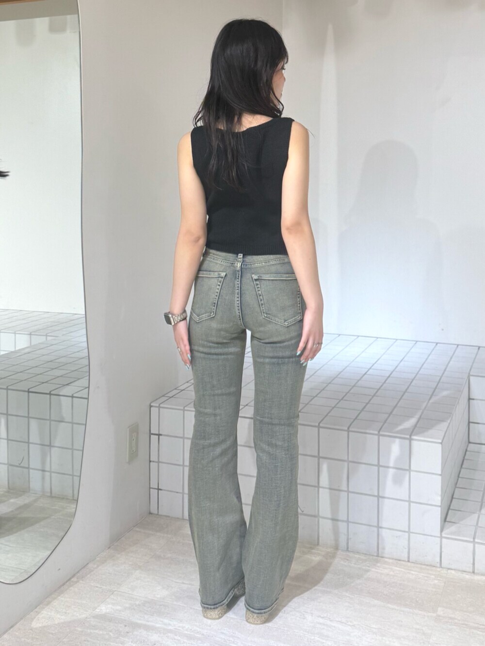 ゴールド系のサンダル、ブルー系のデニムパンツ、ブラック系のニット/セーターを着用したレディースの夏コーディネートの3枚目の写真