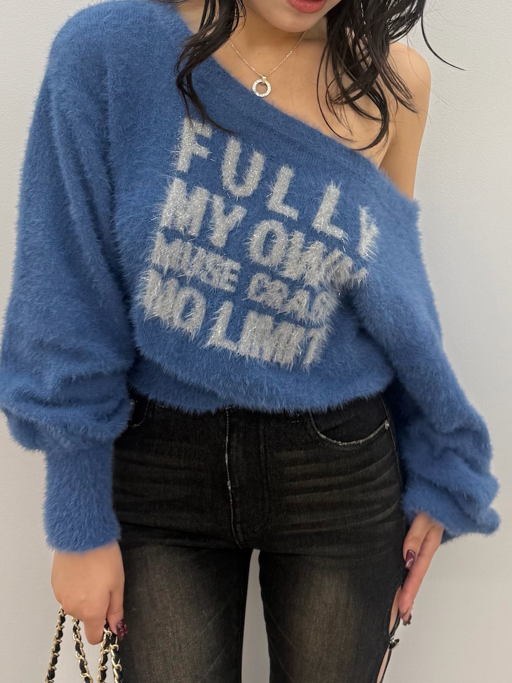 ブルー系のニット/セーター、ブラック系のデニムパンツ、ブラック系のブーツを着用したレディースの秋コーディネートの4枚目の写真