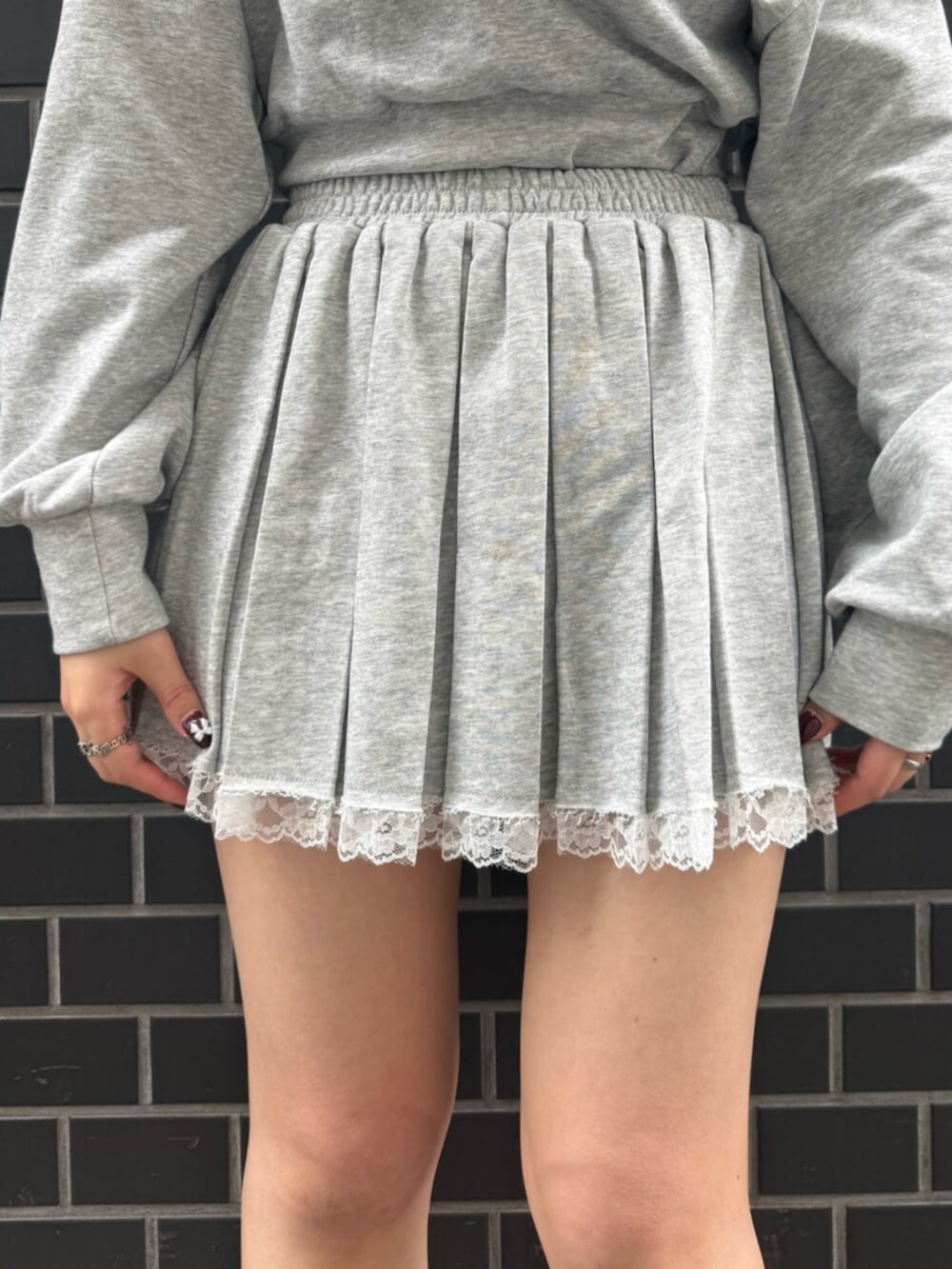 レッド系のパンプス、グレー系のスウェット、グレー系のスカートを着用したレディースの春コーディネートの5枚目の写真