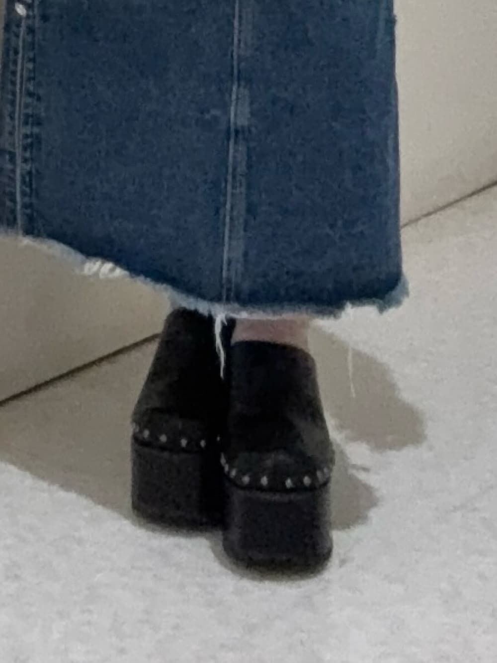 ブラック系のデニムパンツ、ホワイト系のTシャツ/カットソー、ブラック系のサンダルを着用したレディースの春コーディネートの5枚目の写真