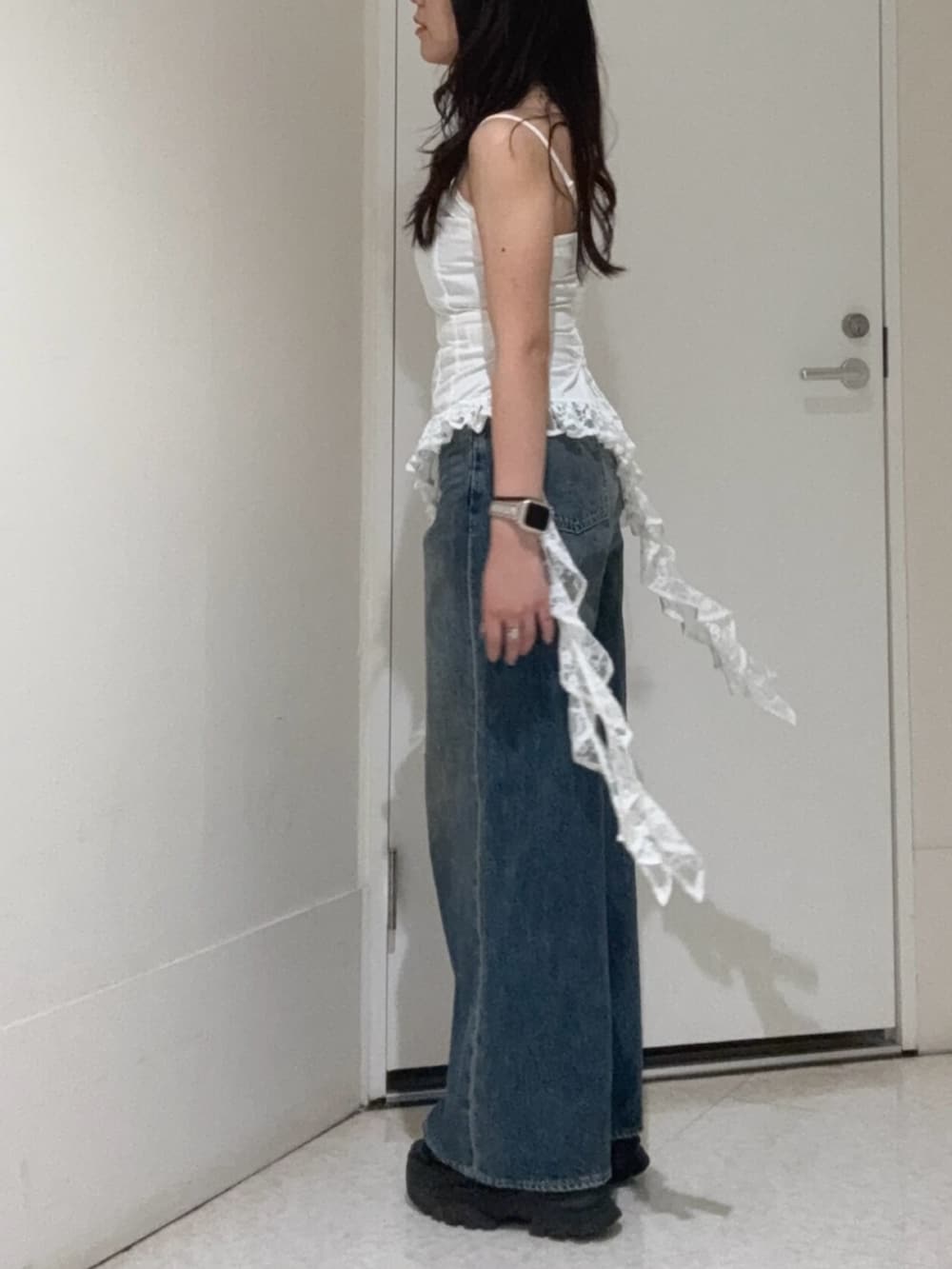 ブラウン系のサンダル、ホワイト系のキャミソール、ブルー系のデニムパンツを着用したレディースの夏コーディネートの2枚目の写真