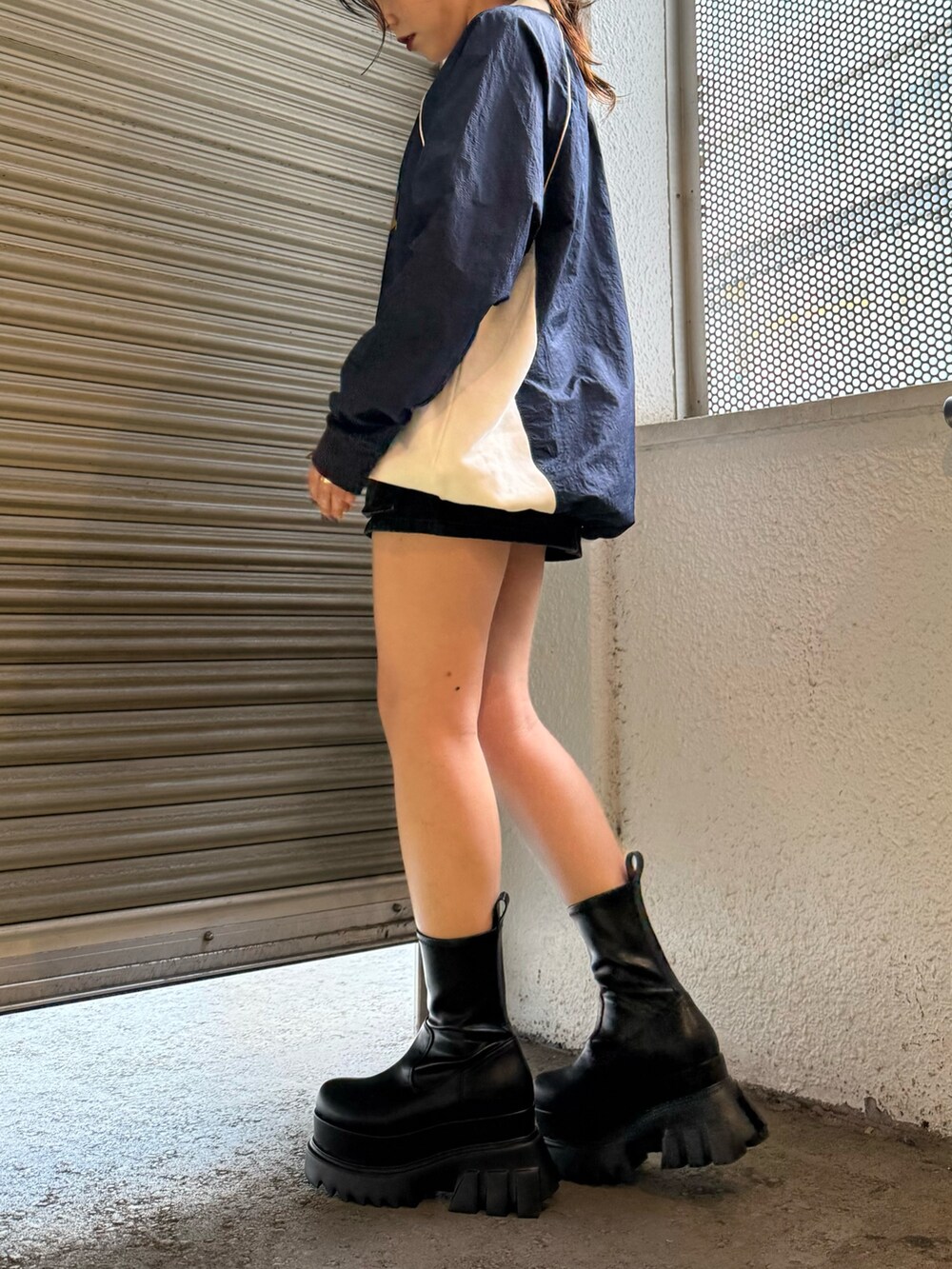 ブラック系のブーツ、ブラック系のデニムスカート、ブルー系のTシャツ/カットソーを着用したレディースの秋コーディネートの2枚目の写真