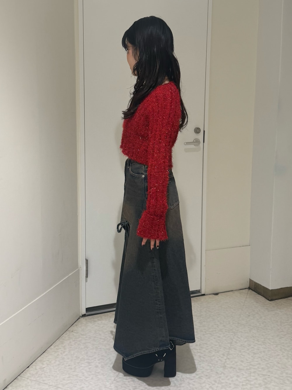 ブラック系のブーツ、ブルー系のデニムスカート、レッド系のカーディガン/ボレロを着用したレディースの秋コーディネートの2枚目の写真