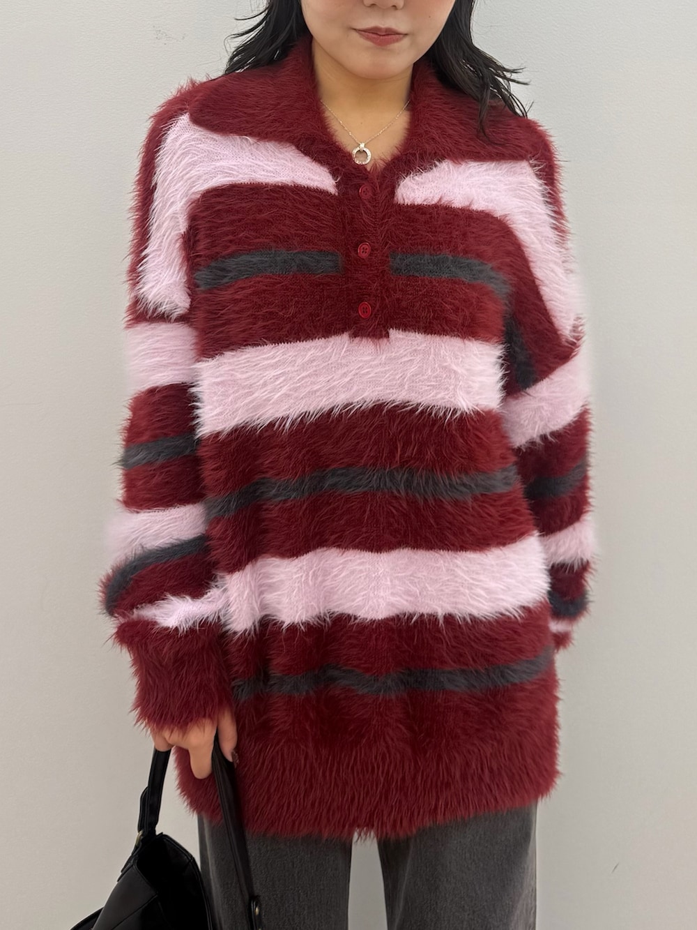 レッド系のニット/セーター、ブラック系のデニムパンツ、レッド系のスニーカーを着用したレディースの秋コーディネートの4枚目の写真