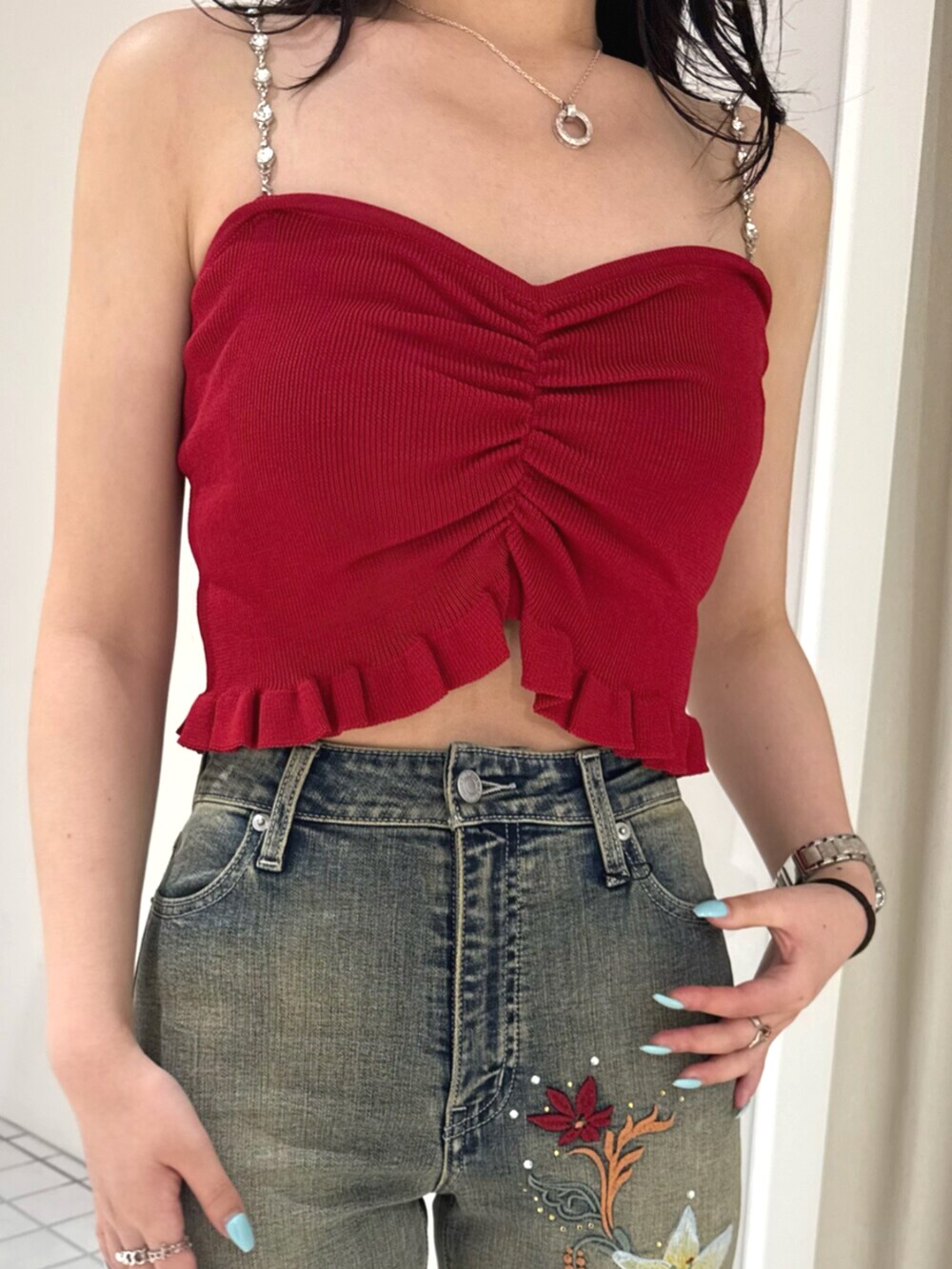 シルバー系のサンダル、ブラック系のデニムパンツ、レッド系のキャミソールを着用したレディースの夏コーディネートの4枚目の写真