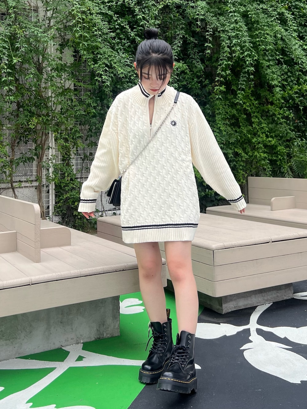 ホワイト系のニット/セーター、ブラック系のブーツ、ブラック系のショルダーバッグを着用したレディースの夏コーディネートの2枚目の写真