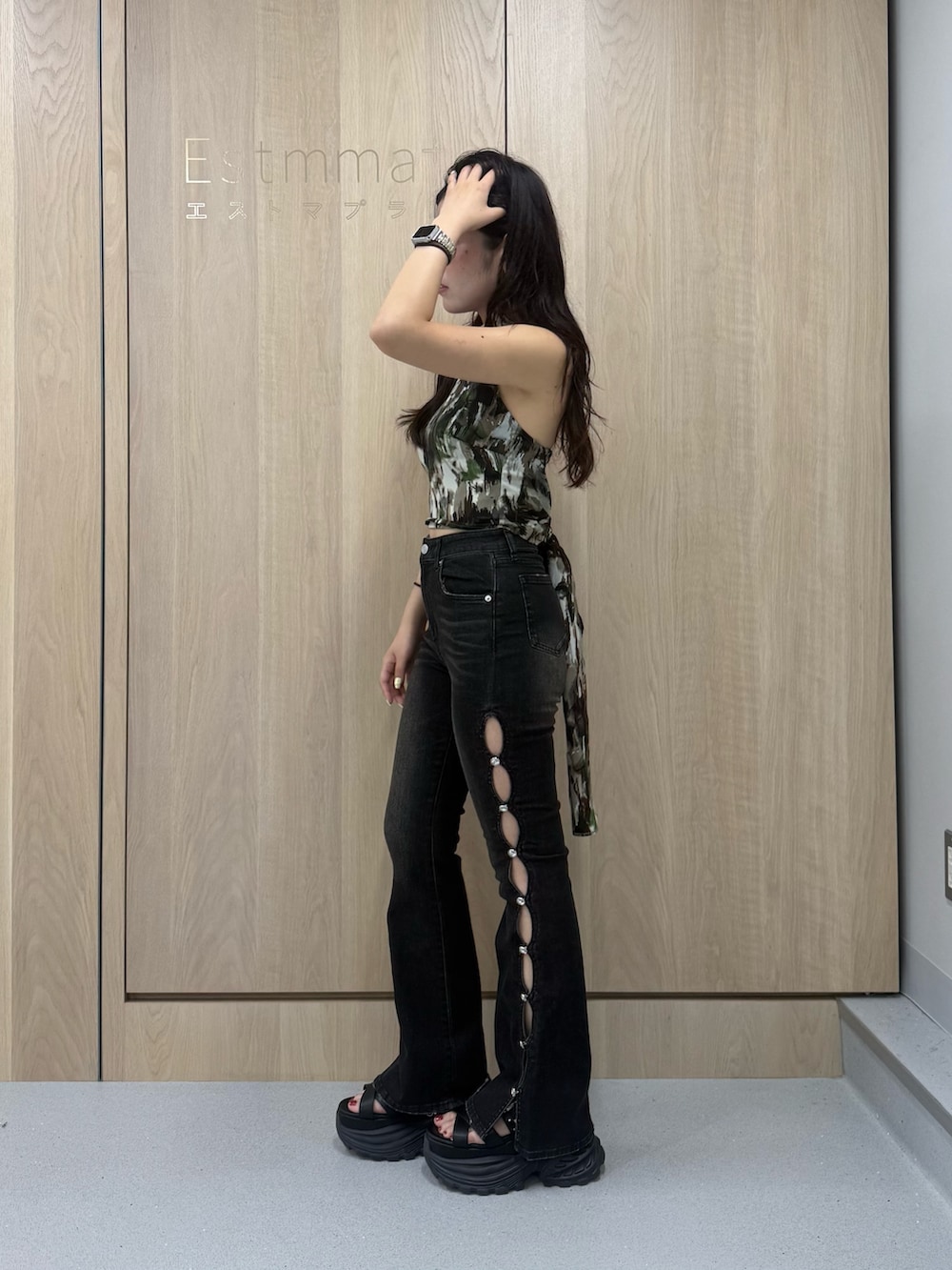 ブラック系のデニムパンツ、グリーン系のキャミソール、ブラック系のサンダルを着用したレディースの夏コーディネートの2枚目の写真