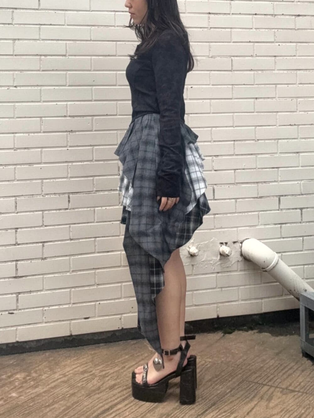 レッド系のTシャツ/カットソー、ブラック系のスカート、ブラック系のサンダルを着用したレディースの春コーディネートの2枚目の写真