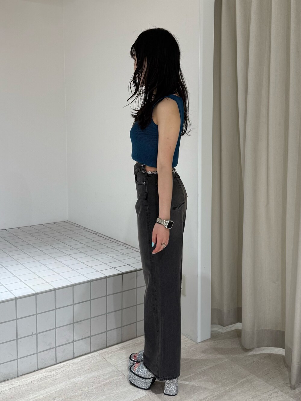 ブルー系のニット/セーター、シルバー系のサンダル、ブラック系のデニムパンツを着用したレディースの夏コーディネートの2枚目の写真