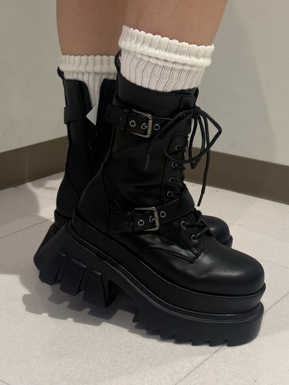 ブラック系のブーツ、グレー系のニット/セーター、ブルー系のデニムパンツを着用したレディースの秋コーディネートの7枚目の写真
