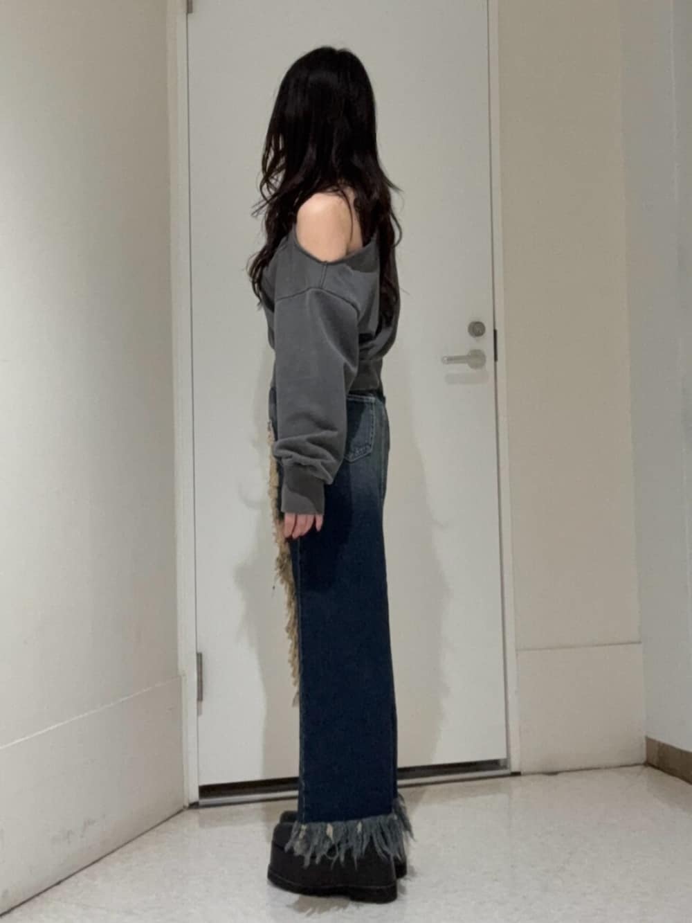 ブラック系のブーツ、ブルー系のデニムスカート、ブラック系のスウェットを着用したレディースの冬コーディネートの2枚目の写真