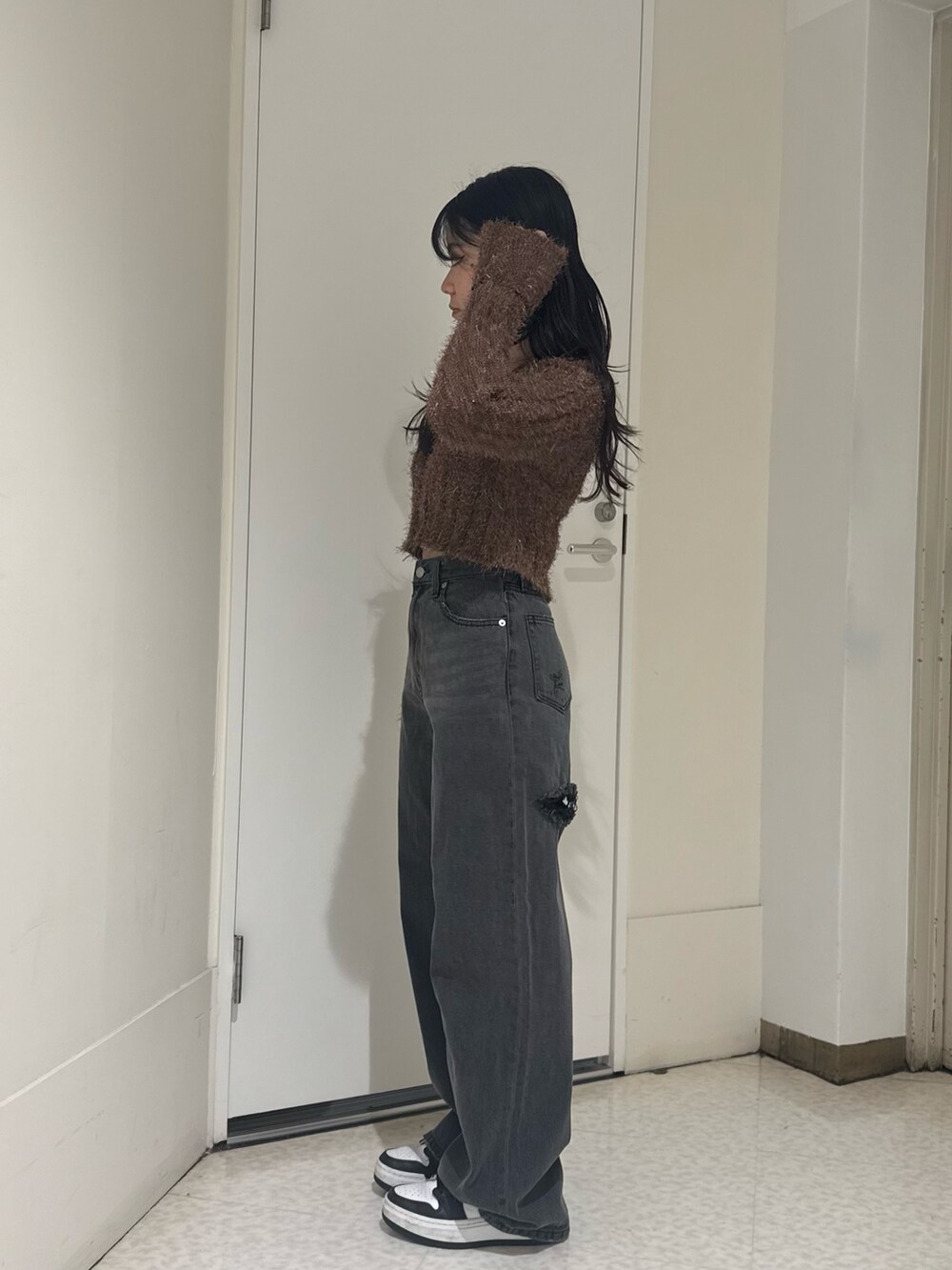 ブラック系のデニムパンツ、ブラウン系のカーディガン/ボレロを着用したレディースの秋コーディネートの2枚目の写真