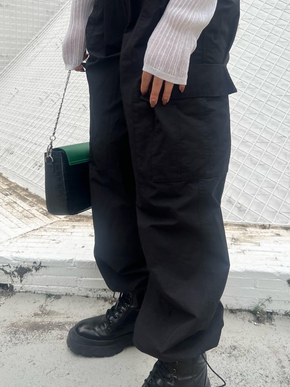 ブラック系のカーゴパンツ、ブラック系のブーツ、ホワイト系のカーディガン/ボレロを着用したレディースの春コーディネートの7枚目の写真