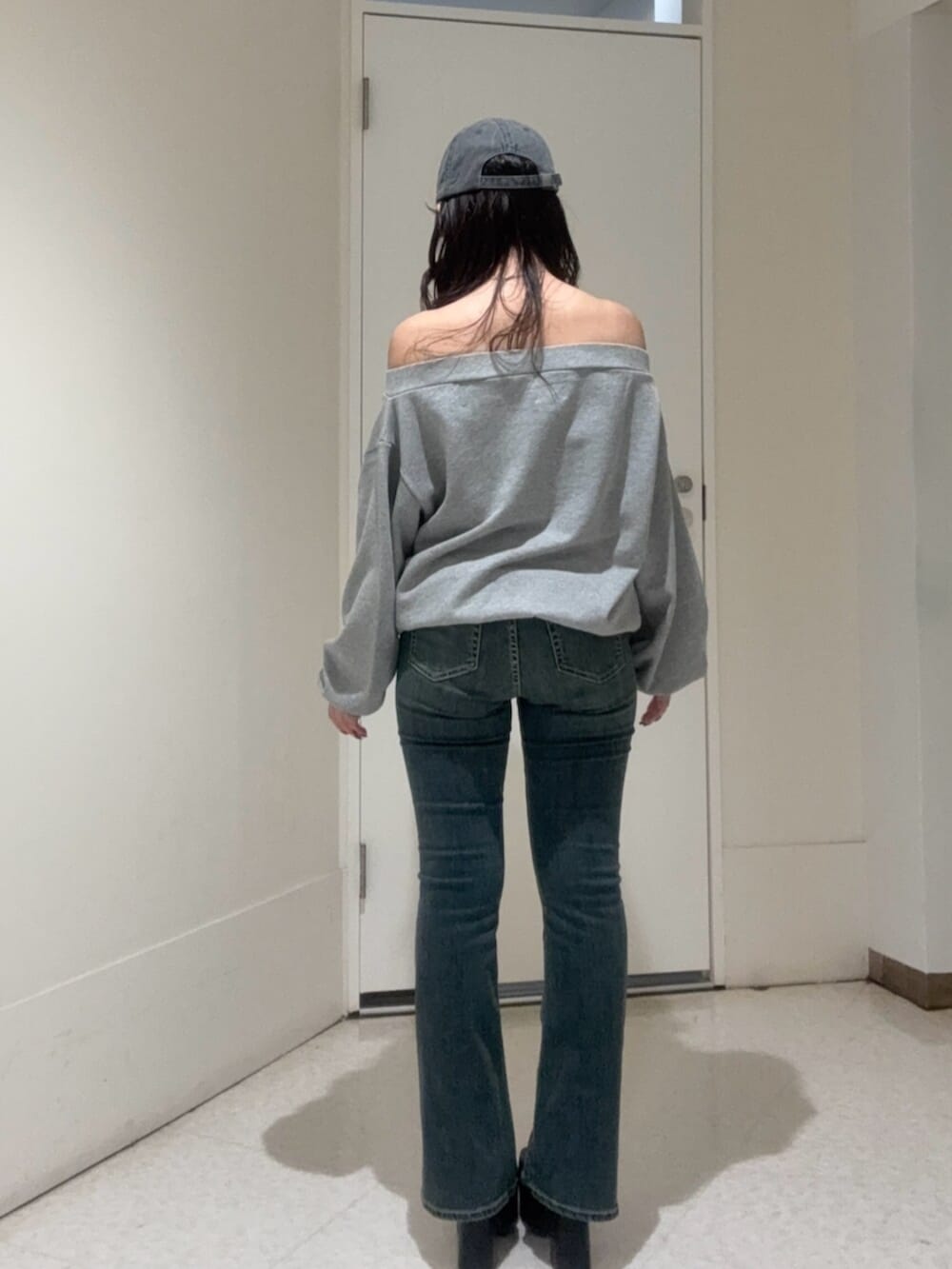 ブラック系のブーツ、グレー系のパーカー、ブルー系のデニムパンツを着用したレディースの秋コーディネートの3枚目の写真