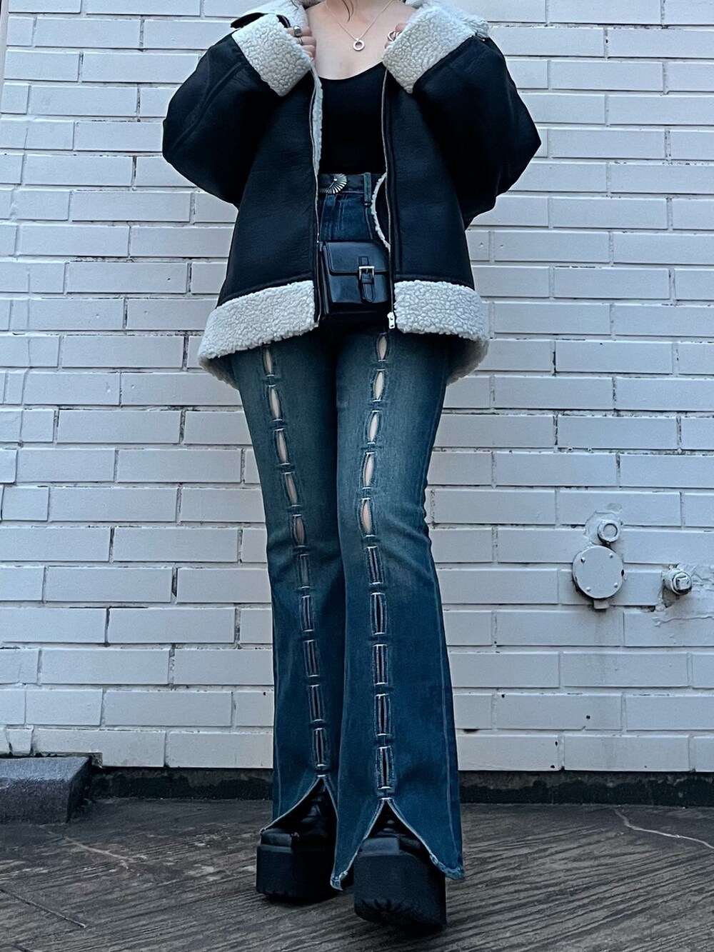 その他のムートンコート、ブルー系のデニムパンツ、ブラック系のショルダーバッグを着用したレディースの夏コーディネートの3枚目の写真