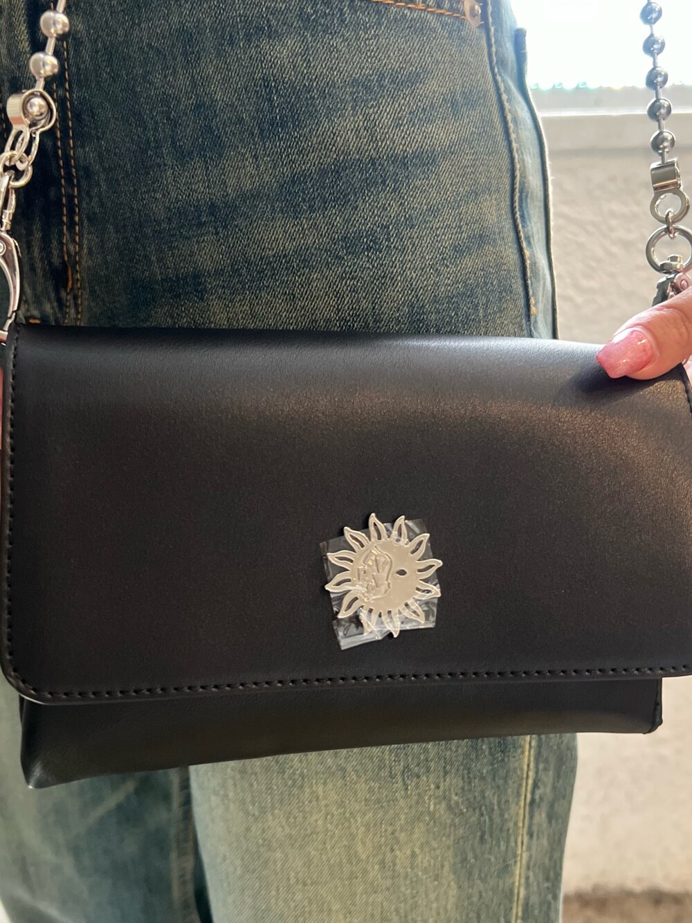 ホワイト系のニット/セーター、ブラック系のブーツ、ブラック系のショルダーバッグを着用したレディースの夏コーディネートの7枚目の写真