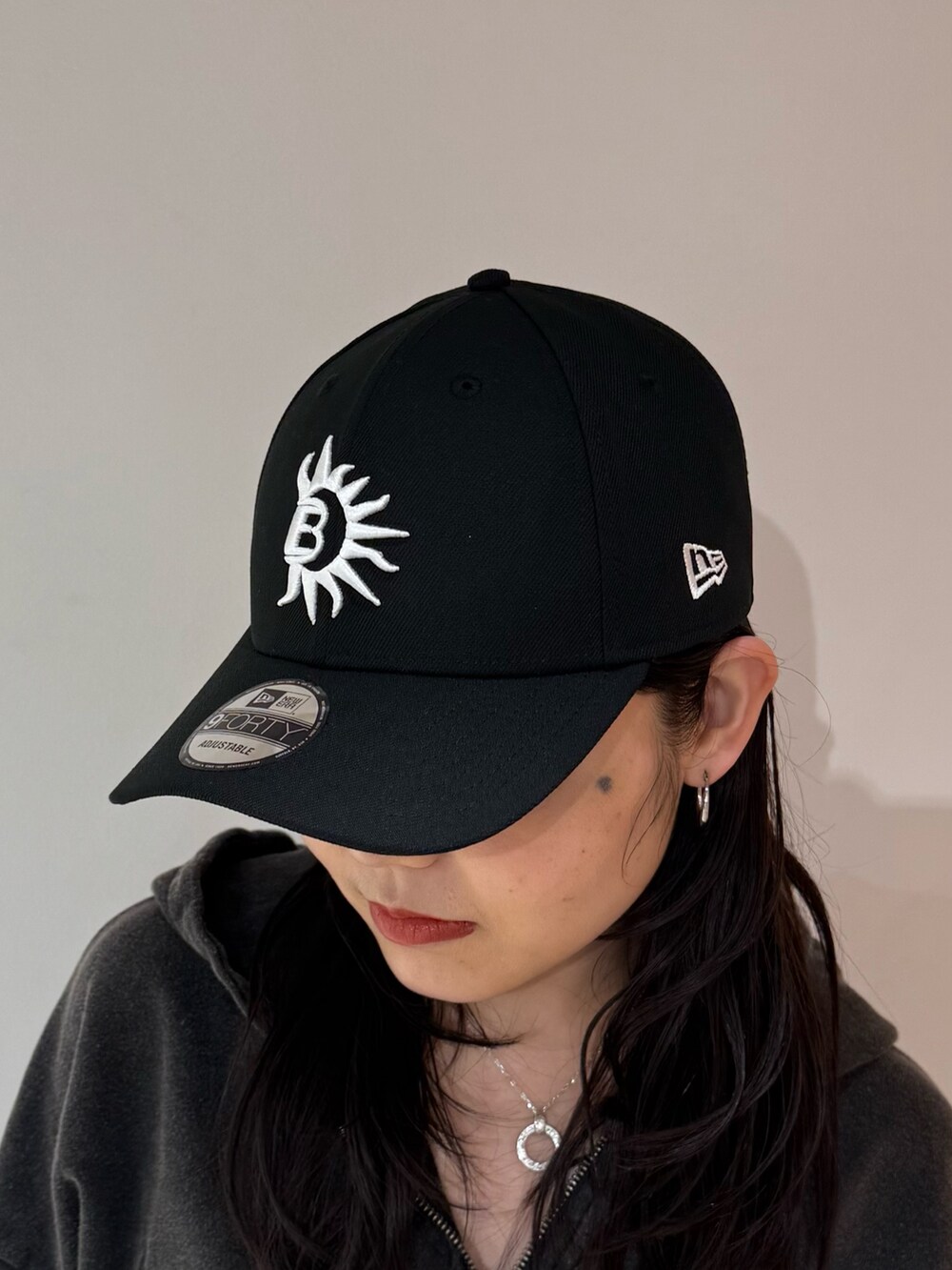 ブラック系のデニムスカート、ブラック系のブーツ、ブラック系のパーカーを着用したレディースの春コーディネートの6枚目の写真