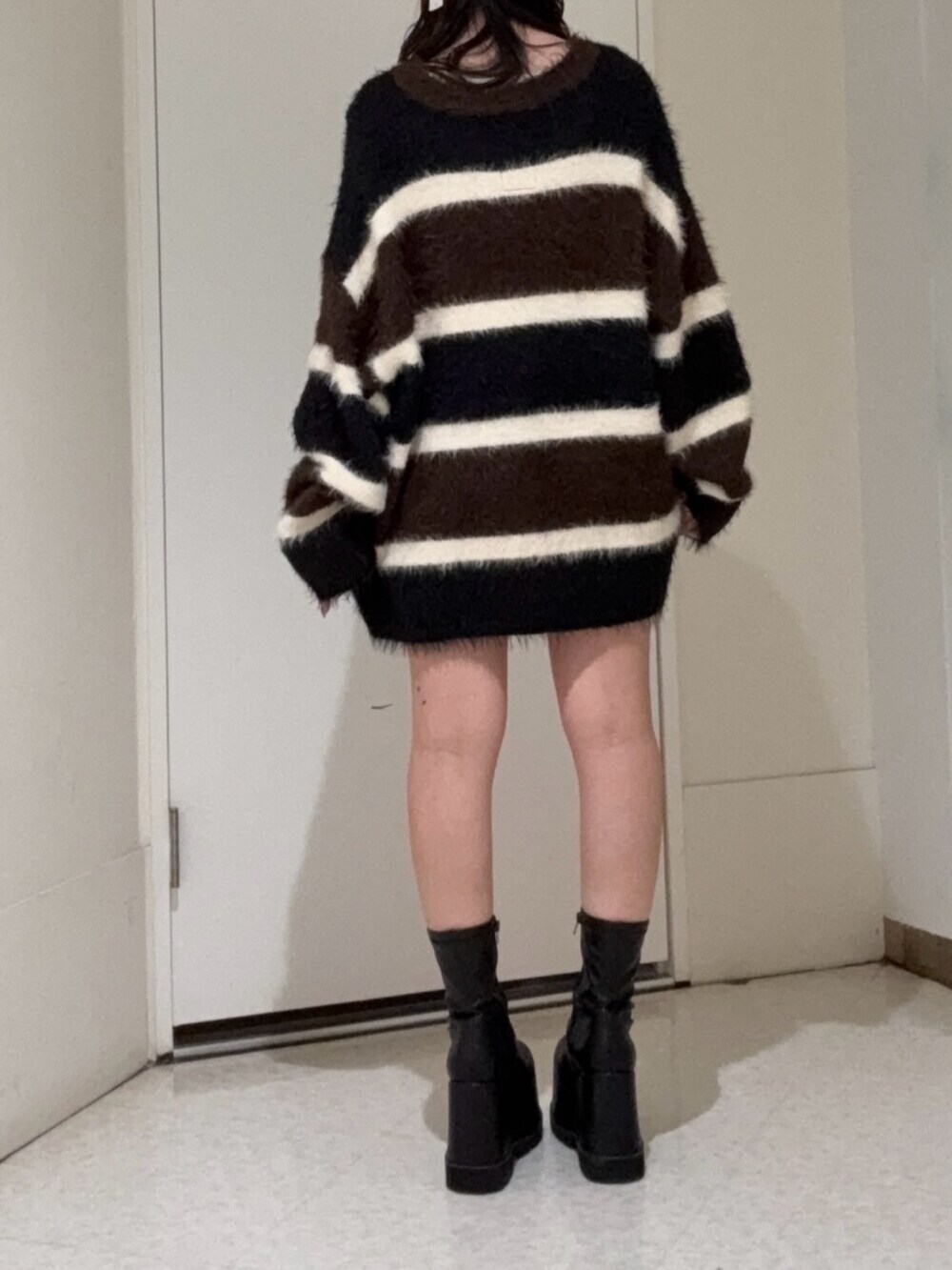 ブラック系のブーツ、ブルー系のデニムパンツ、ブラウン系のニット/セーターを着用したレディースの冬コーディネートの3枚目の写真