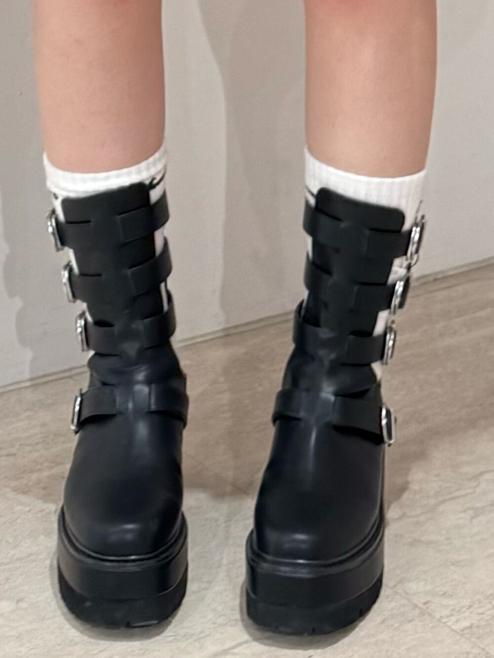 ブラック系のデニムスカート、ブラック系のブーツ、ブラック系のパーカーを着用したレディースの春コーディネートの7枚目の写真