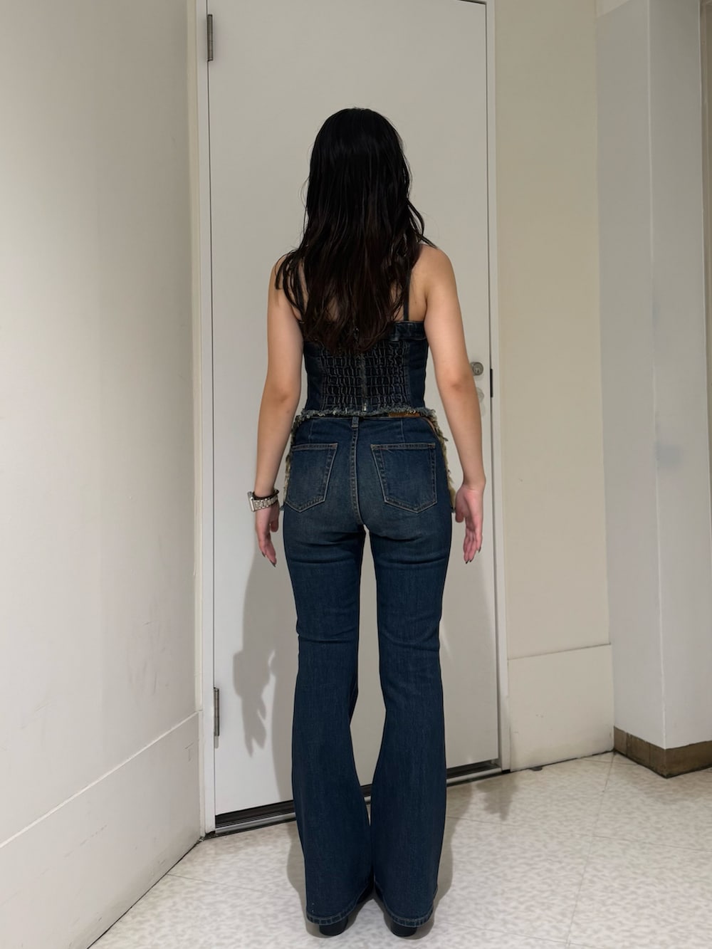 ブルー系のデニムパンツ、ブラック系のブーツ、ブルー系のキャミソールを着用したレディースの夏コーディネートの3枚目の写真